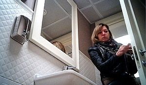 Обнажив попу блондинка не заметила в туалете спрятанную камеру